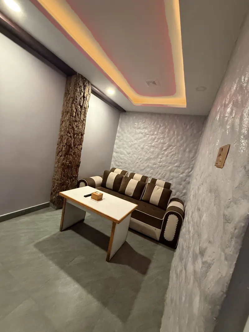 Inside a private cabin at The Lookout: a striped sofa, a table and warm ceiling light